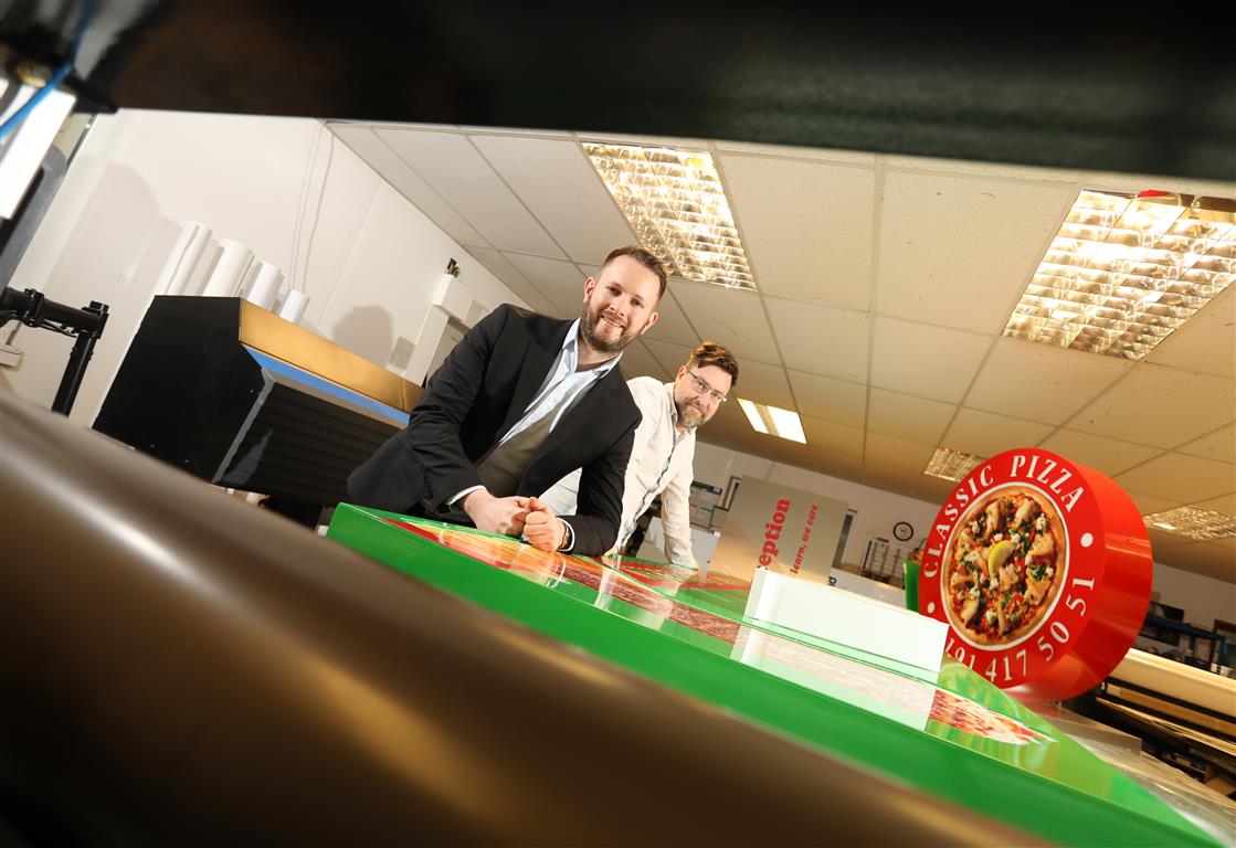 The image shows (left) Mike Guellard of NEL Fund Managers with Greg Economides of Radecal Signs